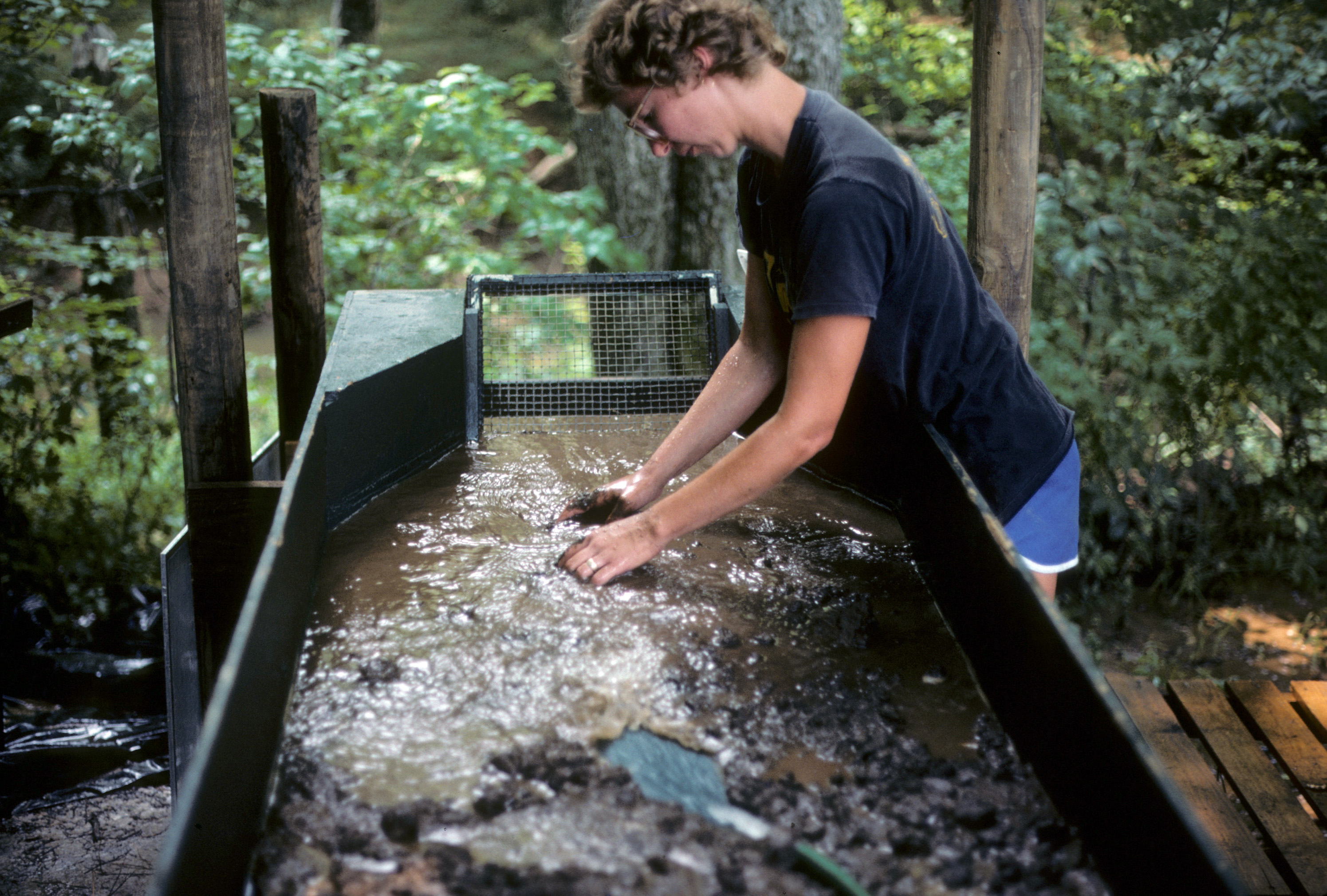 A student is waterscreening soil removed from an archaeological feature. 